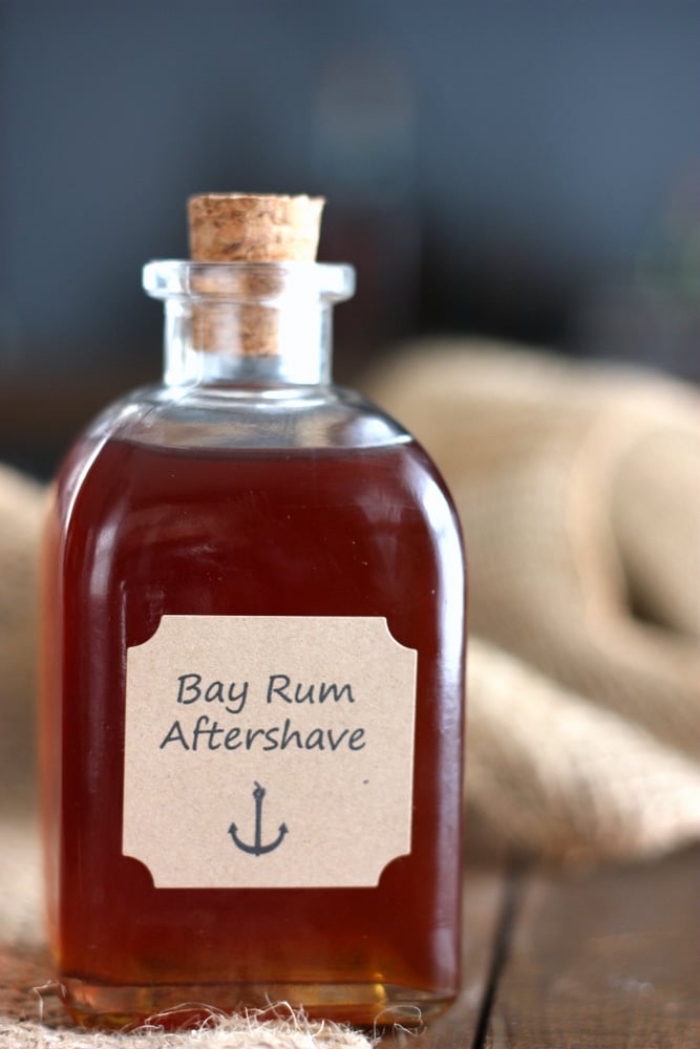 small bottle of bay rum aftershave with cork cap, christmas gifts for boyfriend, placed on wooden surface, step by step diy tutorial