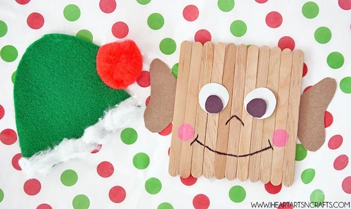 popsicle stick elf, green hat made of felt, christmas crafts for kids, placed on white sheet with red and green dots