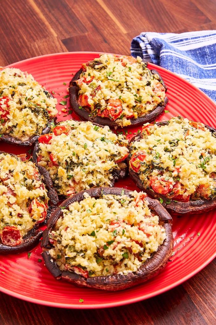 stuffed portobello mushrooms, christmas eve appetizers, arranged on red plate, placed on wooden surface