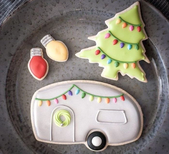 royal icing recipe for sugar cookies, cookies in the shape of caravan and christmas tree and lights, placed on grey plate
