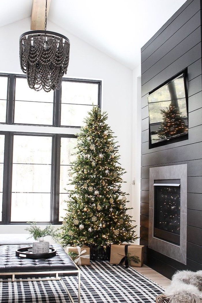 tree placed in the corner with presents underneath, how to decorate a christmas tree with ribbon, decorated with silver and gold ornaments