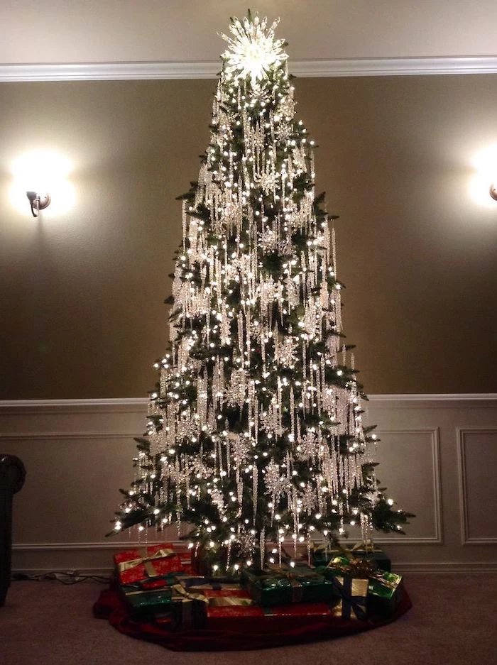 tree with lots of lights, decorated with crystal hanging ornaments, tree decorating ideas, wrapped presents underneath