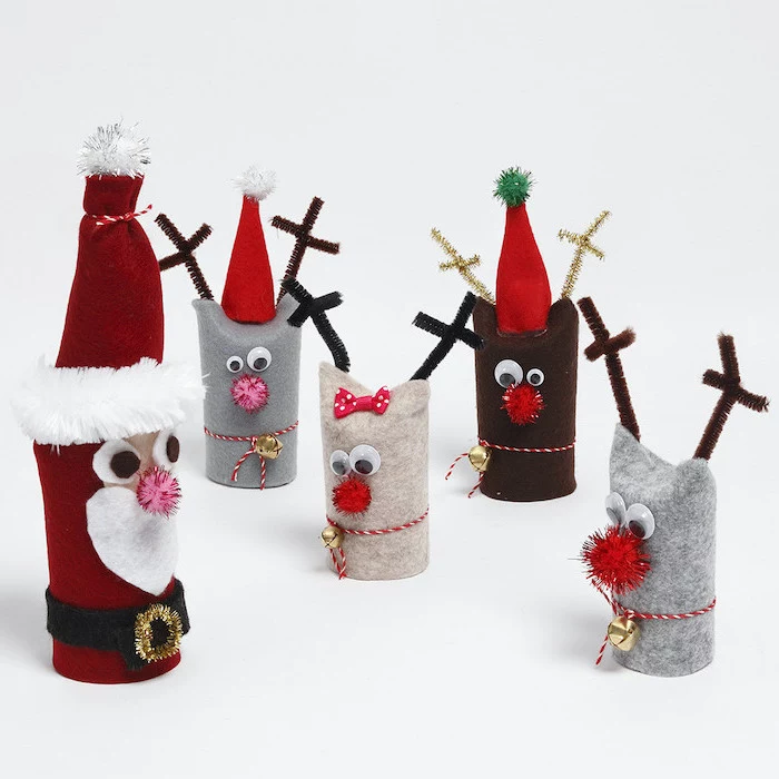 toilet paper rolls covered with felt, turned into santa and his reindeer, christmas crafts for toddlers age 2 3, placed on white surface