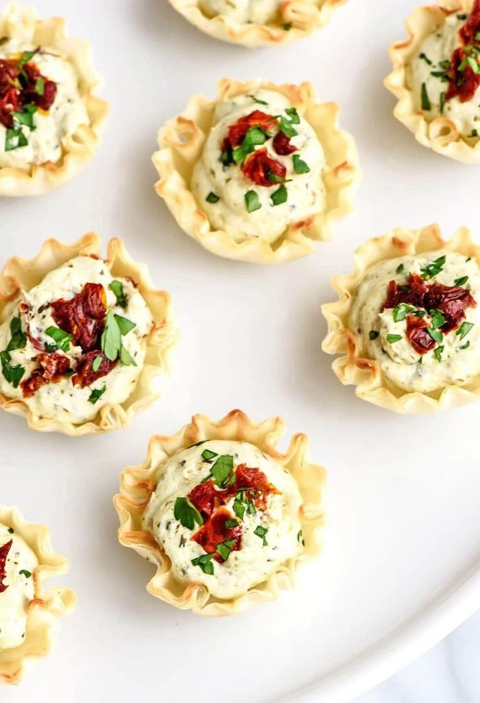 tomato pesto filled bites, sun dried tomatoes and parsley on top, easy appetizers finger foods, arranged on white plate
