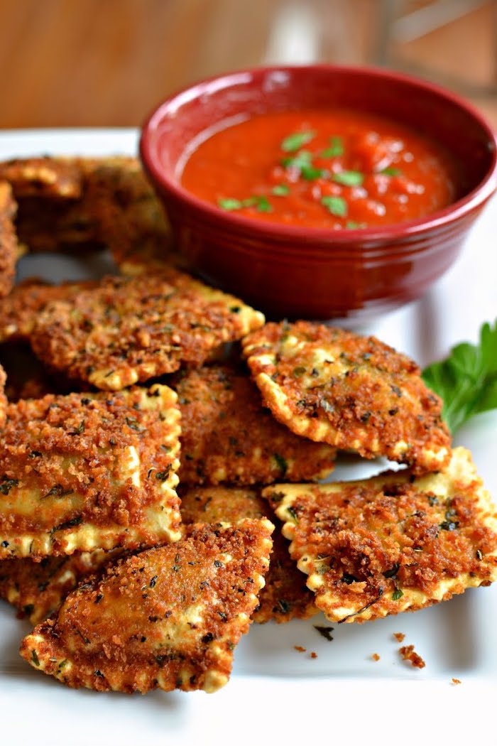 ceramic bowl full of tomato sauce, parsley garnish on top, easy appetizers finger foods, toasted ravioli on white plate