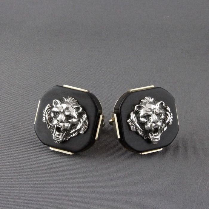 two cufflinks, black with two roaring lion heads, thoughtful christmas gifts for boyfriend, placed on grey surface