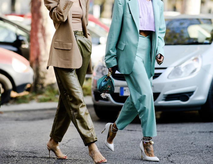 clothing trends 2019, two women walking down the street, one wearing green leather pants, turquoise suit with white heels