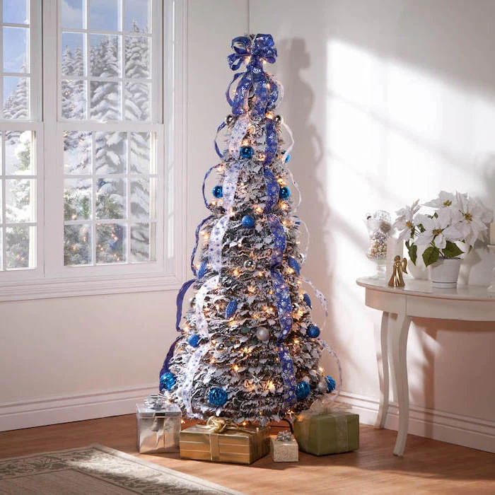 blue and silver ribbons wrapped around a tree, christmas decorations indoor ideas, silver and blue ornaments, wrapped presents underneath