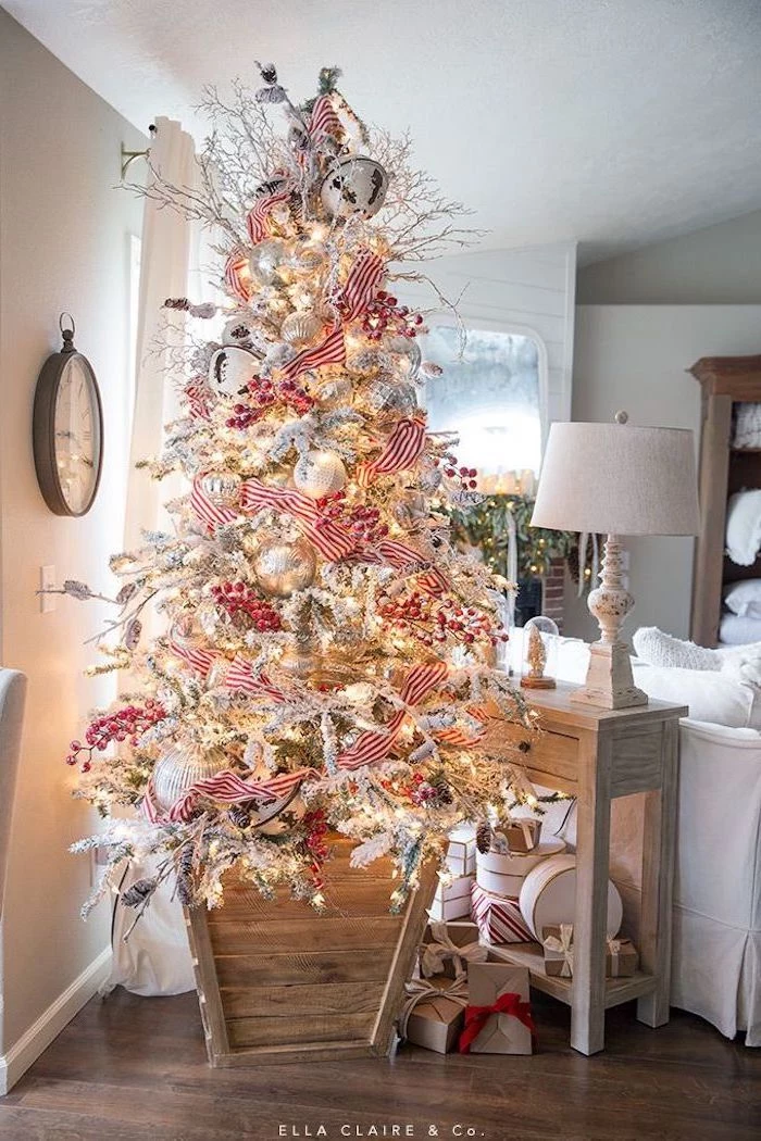faux tree with faux snow, christmas decorations indoor ideas, red and white ribbon, white and silver ornaments