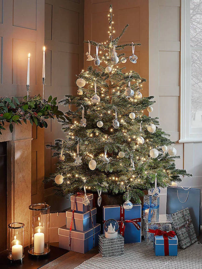 wrapped presents underneath a tree, silver and gold ornaments, christmas decorations indoor ideas, tree with lots of lights