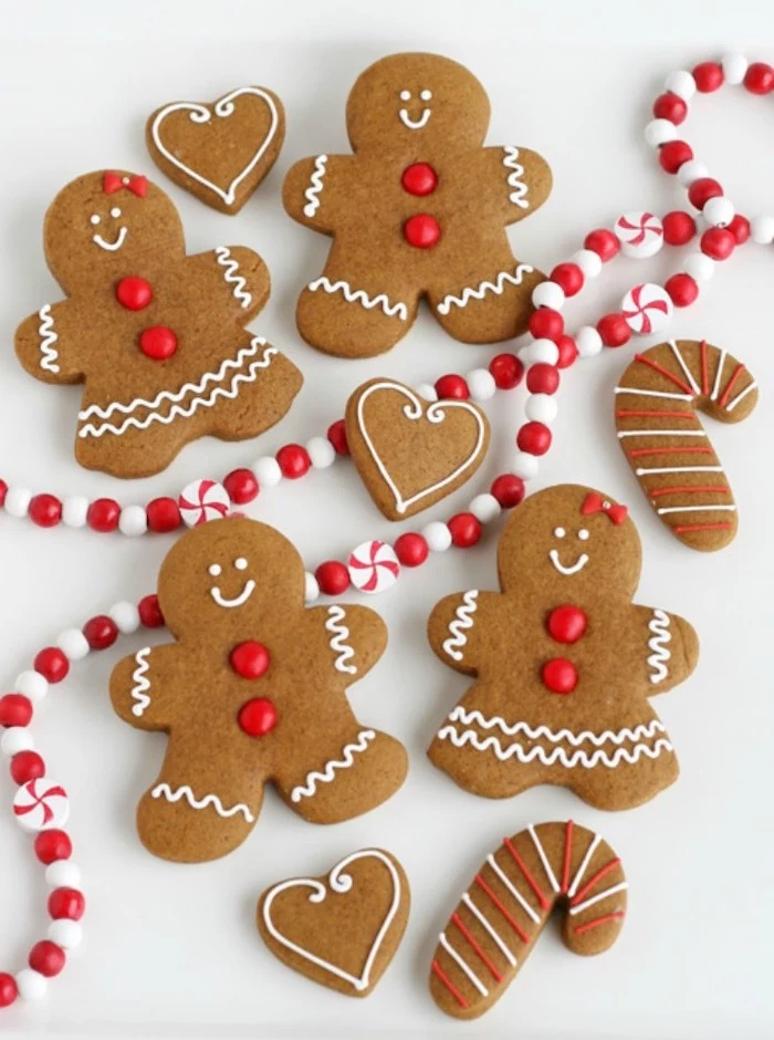 gingerbread men and women, decorated with white icing and red sprinkles, how to make royal icing for cookies