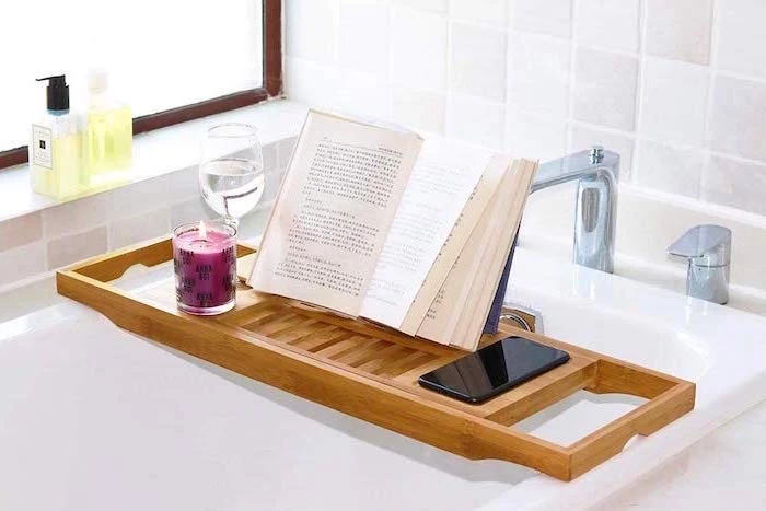 wooden bathtub caddy tray, placed over white bath tub, book and candle on top, meaningful gifts for mom, white tiles