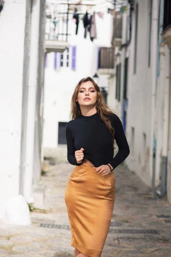 woman standing on the street, wearing brown silk skirt and black blouse, clothing trends 2019, long brown hair
