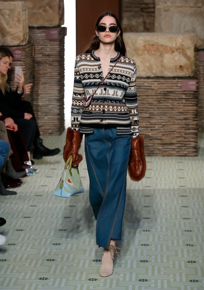 new york winter fashion, model walking down the runway, wearing jeans and printed cardigan, brown leather gloves