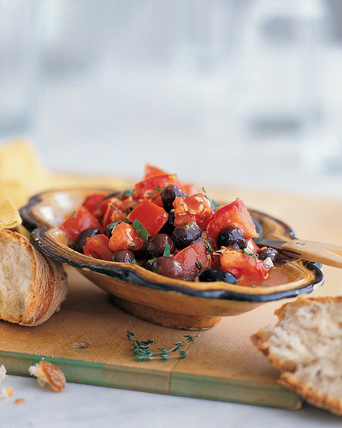 ceramic bowl filled with salad, chopped tomatoes and black beans, placed on wooden board, christmas party snacks