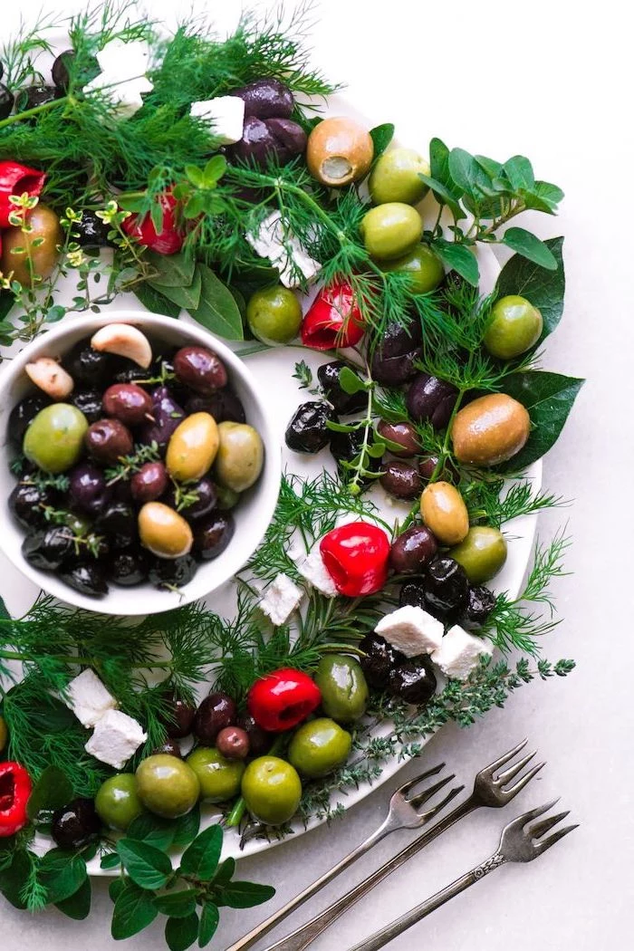 christmas party food ideas finger foods, wreath made of herbs, olives and feta cheese, bowl of olives in the middle
