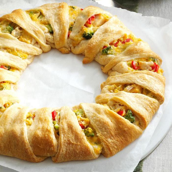 christmas wreath made of dough, broccoli and cheese, peppers and tomatoes inside, christmas party food ideas finger foods