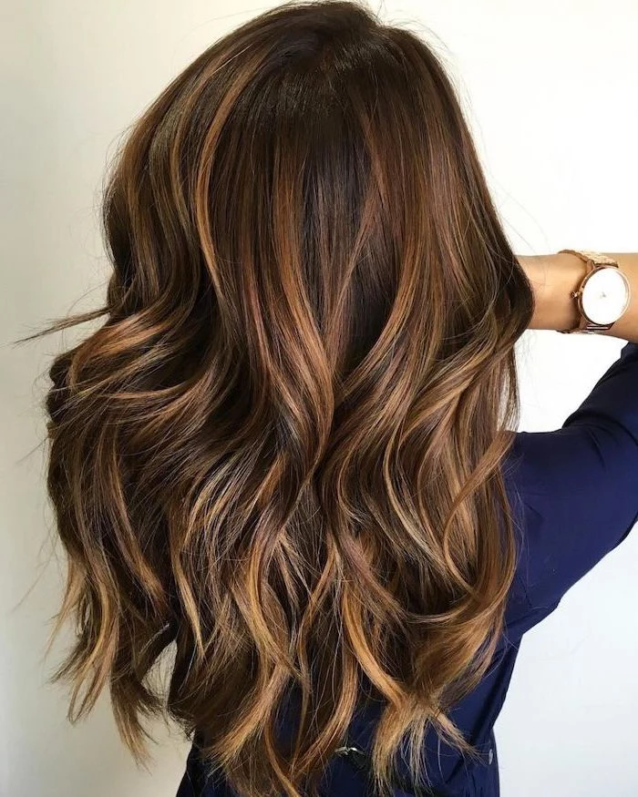 woman wearing blue shirt, 2020 hair color trends for brunettes, balayage brown hair with highlights, long wavy hair