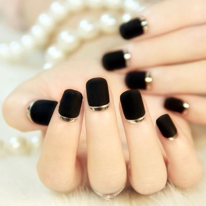 black matte nail polish with gold lines at the bottom, short squoval nails, white and gold nails