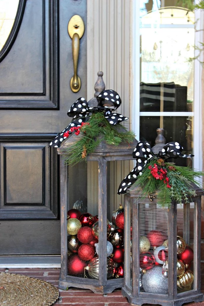 two wooden lanterns, filled with baubles, black ribbons with white polka dots on top, large outdoor christmas decorations