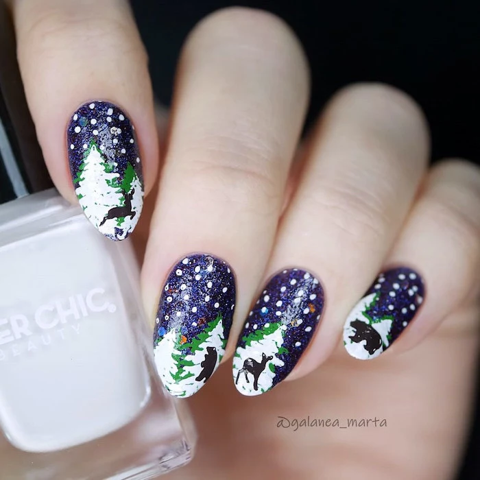 blue glitter nail polish on almond nails, white and gold nails, snowy trees decorations on each nail