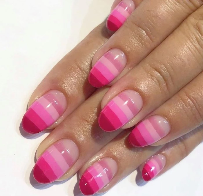 all shades of pink nail polish on each nail, short almond nails, glitter ombre nails, white background
