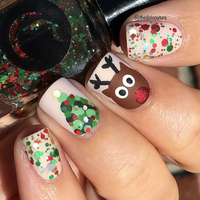christmas themed decorations on short nails, beige nail polish, nail colors, hand holding a nail polish bottle