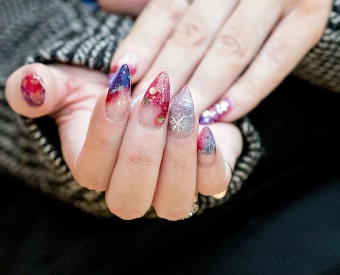 stiletto nails, blue red silver glitter nail polish, different decorations with rhinestones on each nail, different color nails