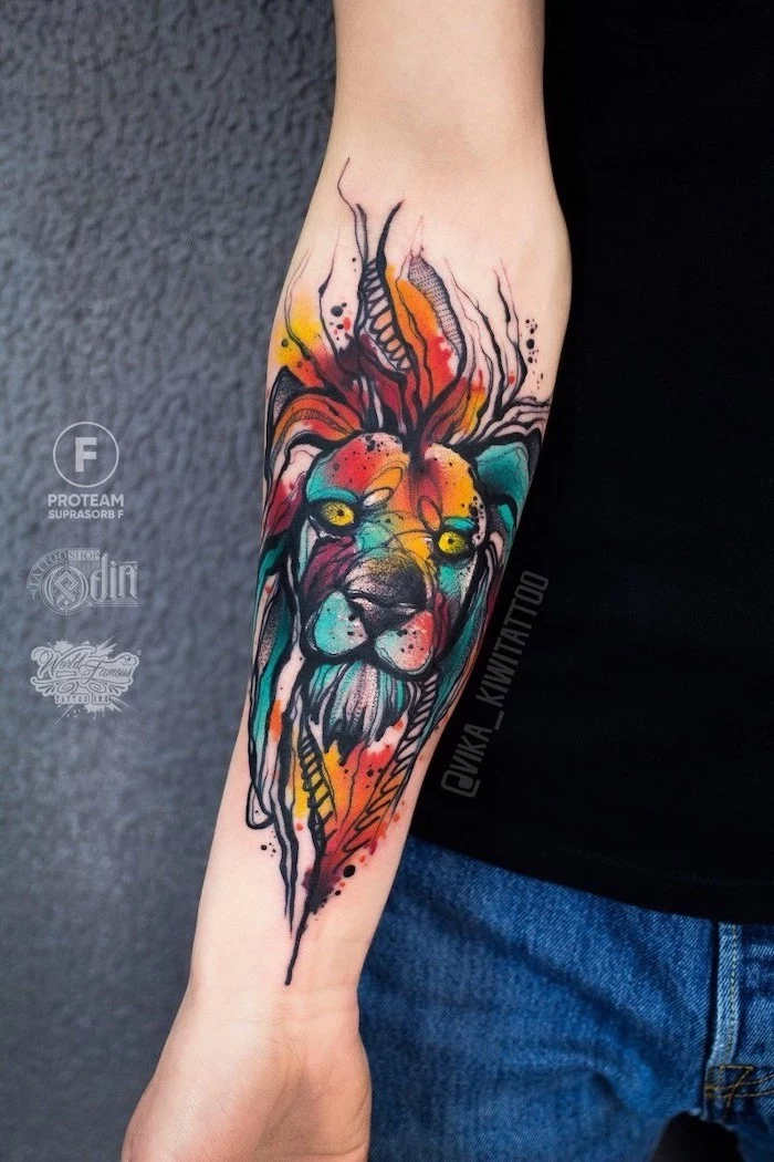 lion forearm tattoo, lion head with mane, watercolor forearm tattoo, mane in different colors, on woman wearing jeans and black top
