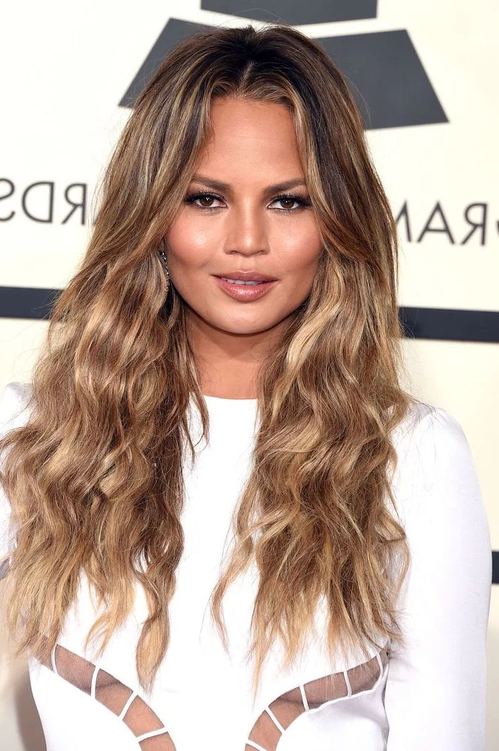 crissy teigen with long wavy hair, balayage caramel brown hair with highlights, fall hair colors for blondes, wearing white dress