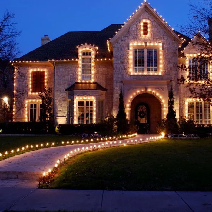 large two storey house, decorated with lots of lights, outdoor christmas decorations ideas, lights along the pathway