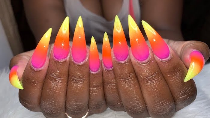 yellow to orange and pink gradient nail polish, extra long stiletto nails, ombre acrylic nails, ring on the ring finger