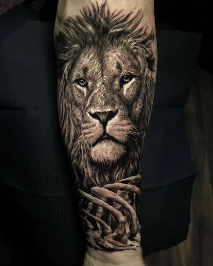 lion head with mane, bones in front of it, lion forearm tattoo, black background