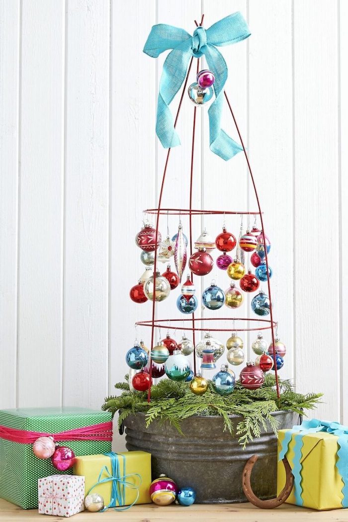 tomato cage with baubles and blue ribbon on top, christmas porch decorations, wrapped presents underneath, white background