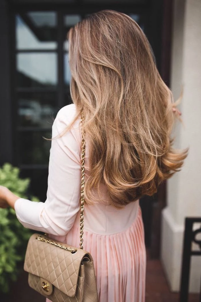 woman wearing pink dress, brown leather cross body bag, hair color trends fall 2020, long wavy hair, brown with highlights