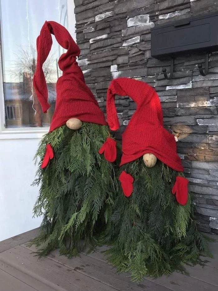 gnomes made of tree branches, red hats and gloves, front porch christmas decorations, placed on wooden porch