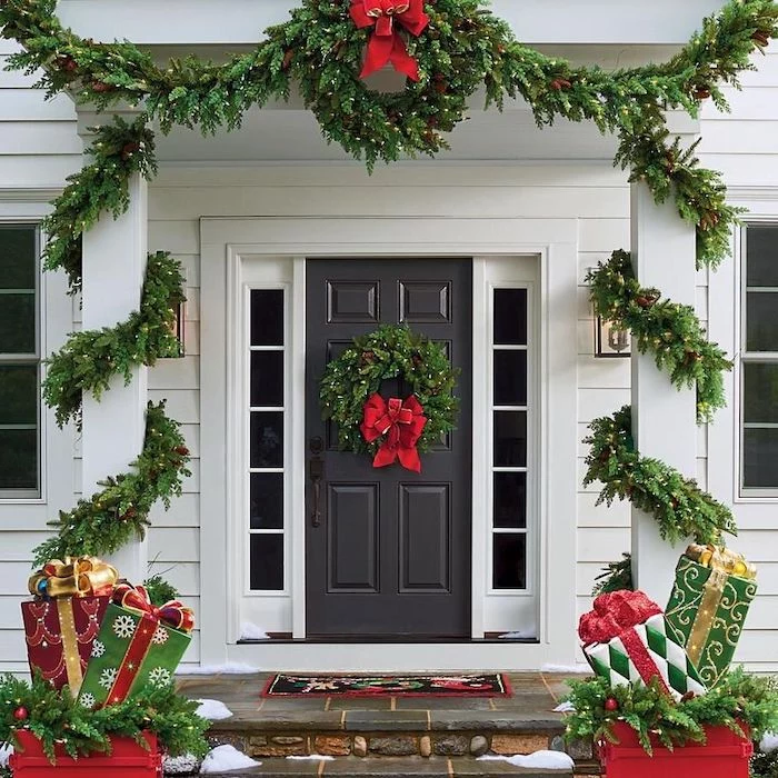 wreaths with lights and red ribbons, hanging on door and door frame, front porch christmas decorations, presents figurines on both sides