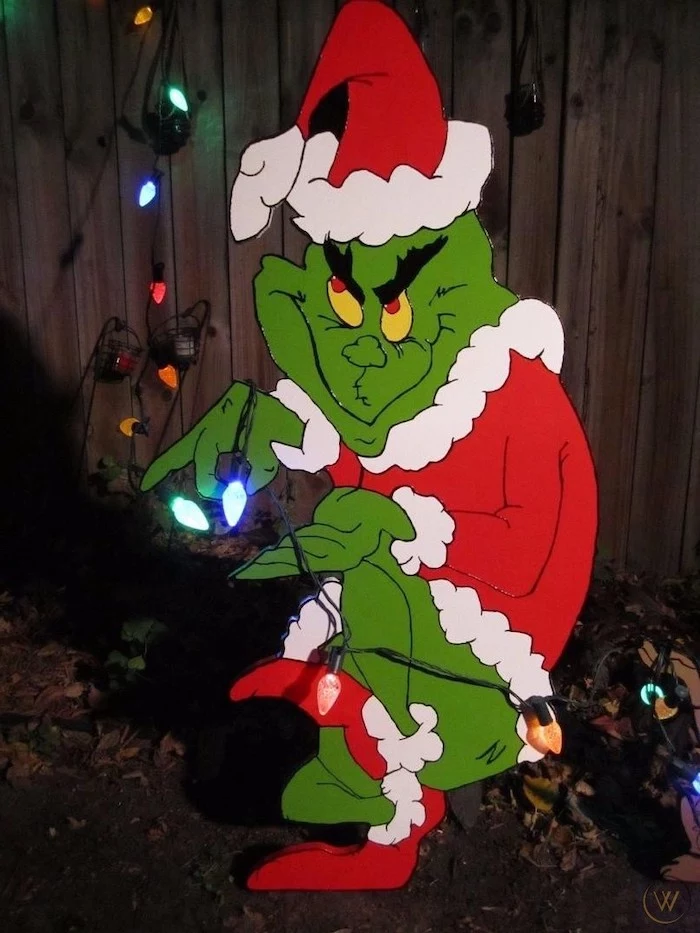 grinch figurine made out of carton, colorful lights around it, diy outdoor christmas decorations, placed in the front yard