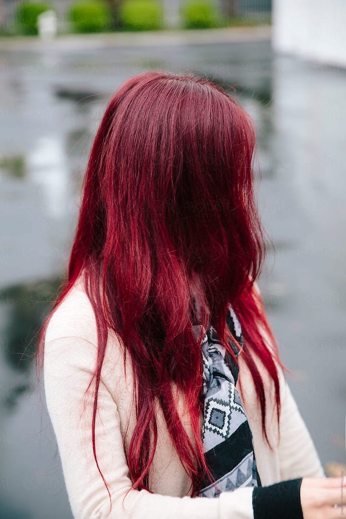 woman wearing nude sweater and scarf, long wavy dark red hair, brunette highlights