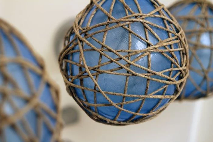 blue balloons, twine wrapped around them, outdoor christmas decorations ideas, step by step diy tutorial