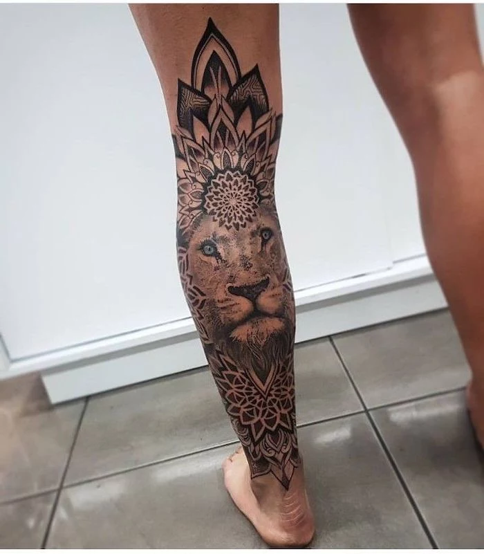 large back of leg tattoo, lion hand tattoo, mandala lion tattoo, lioness head with blue eyes, surrounded by mandala flowers