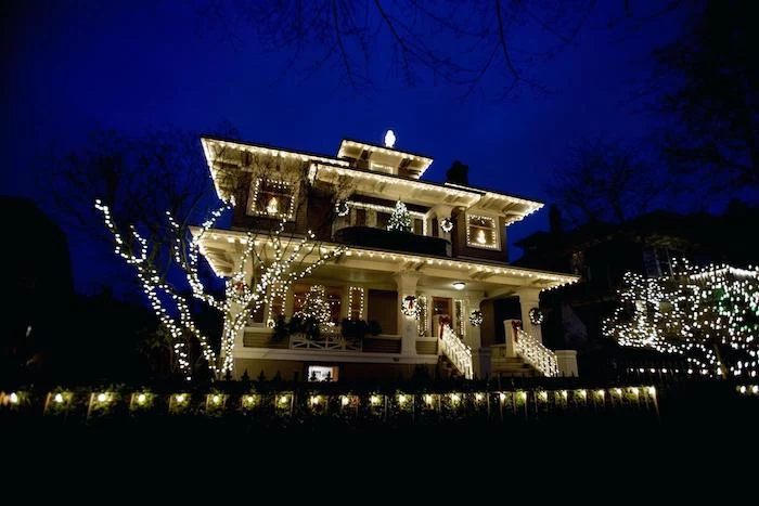 large two storey house, covered with lights, outdoor lighted nativity scene, trees covered with lights in the front yard