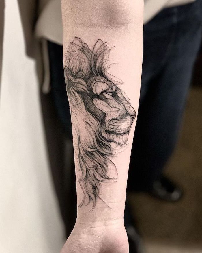 profile of a lion head, lion shoulder tattoo, forearm tattoo, blurred background