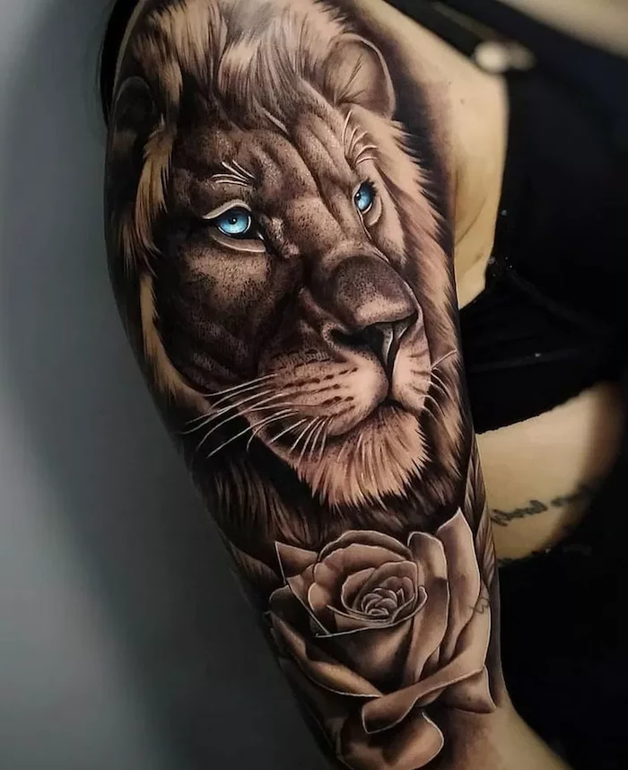 lion head with blue eyes, rose underneath, shoulder tattoo, lion tattoo meaning, woman wearing black top