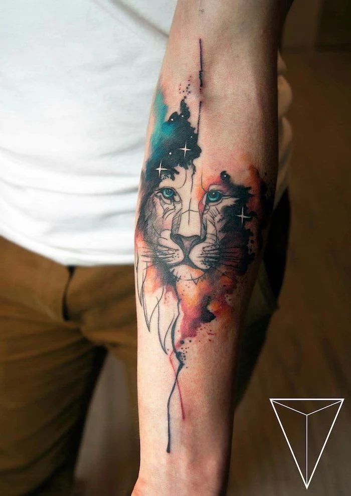 watercolor forearm tattoo, lion tattoo meaning, lion head with blue and orange watercolor mane