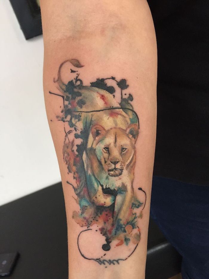 lioness walking, watercolor tattoo, forearm tattoo, lion tattoo on arm, black orange and blue colors