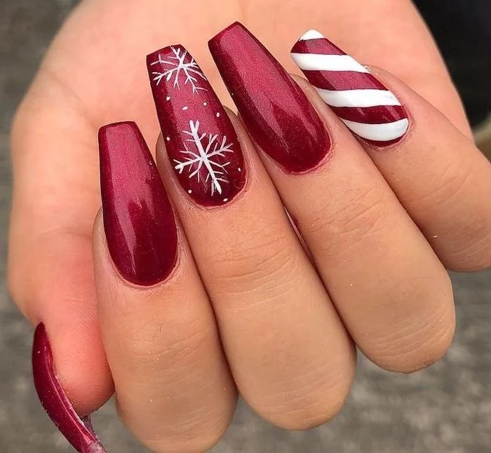 red glitter nail polish, cute nail colors, snowflakes decoration on middle finger, candy cane decoration on pinky