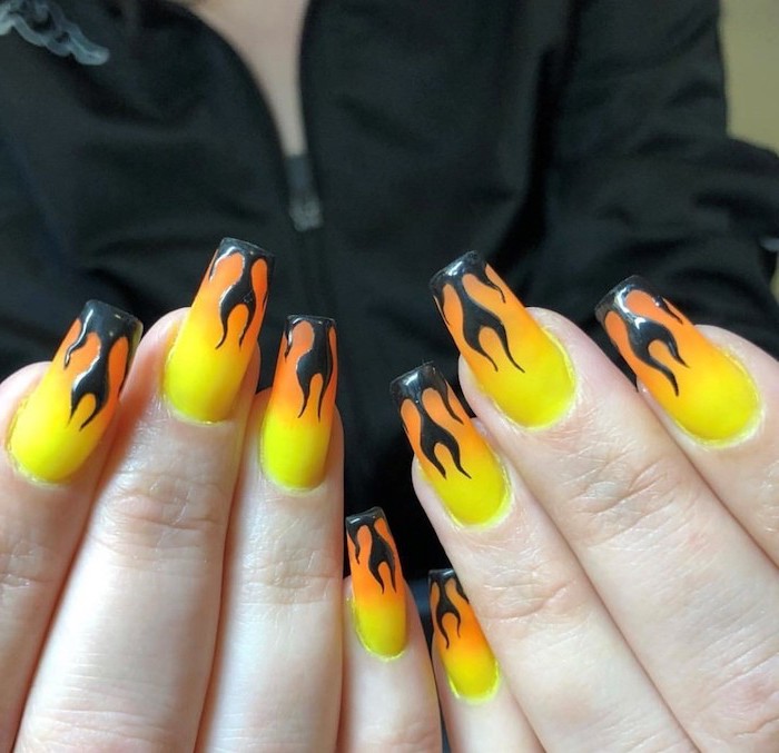 yellow to orange gradient matte nail polish, black flames decorations on each nail, nude ombre nails, long square nails