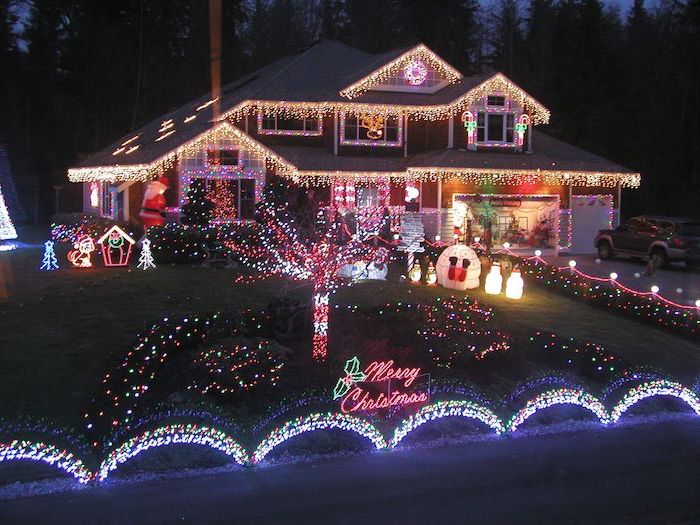 two storey house, covered with lights, outdoor lighted nativity scene, lots of lighted figurines in the front yard