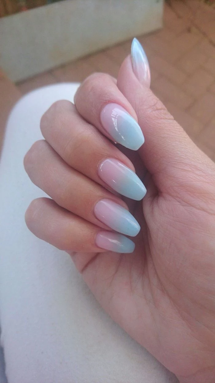 pink to blue gradient nail polish, pink ombre nails, female hand leaning on white surface, with long coffin nails
